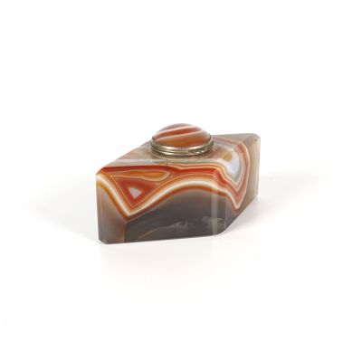 une boîte en marbre surmontée d'une bague, posée sur une surface blanche