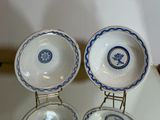 three blue and white dishes are on a stand on a table