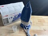 an image of a blue and white iron sitting on top of a wooden table