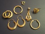 a lot of gold rings and earrings on a table