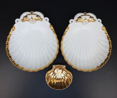 une paire de coquilles Saint-Jacques blanches et dorées sur fond noir