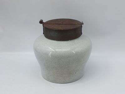 pot en céramique beige et blanc avec un couvercle en bois, sur fond blanc