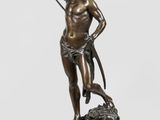une statue en bronze représentant un homme avec un chien, posée sur un socle en marbre