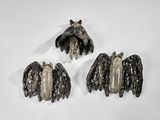 trois pièces de métal noir et argenté sur une surface blanche