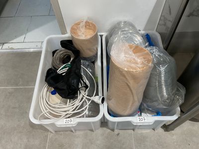 two bins with different items in them sitting on the floor