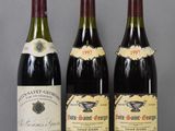 three bottles of wine are lined up on a table