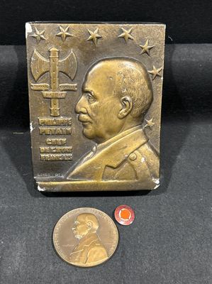 une photo d'une plaque en bronze sur laquelle figure le portrait d'un homme