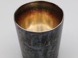 an image of a metal cup on a white surface