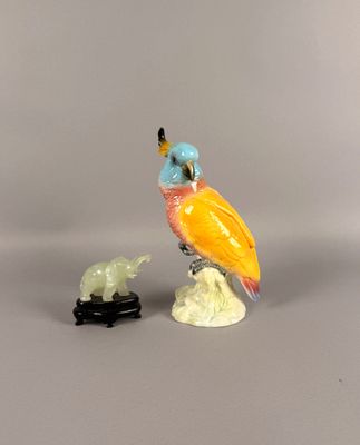 une figurine représentant un oiseau perché sur un rocher, à côté d'une statue représentant un oiseau