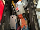 a black plastic container filled with assorted items on the floor