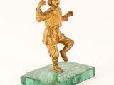 gold figurine of a man on a marble base on a white background