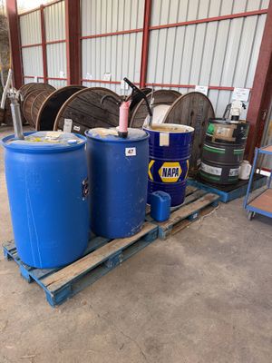 two blue barrels sitting on a pallet in a warehouse