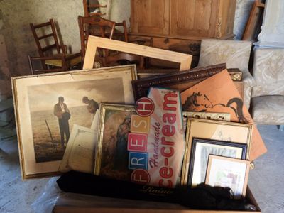 a box full of framed pictures and pictures on the floor