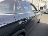 a black car parked in a parking lot with other cars