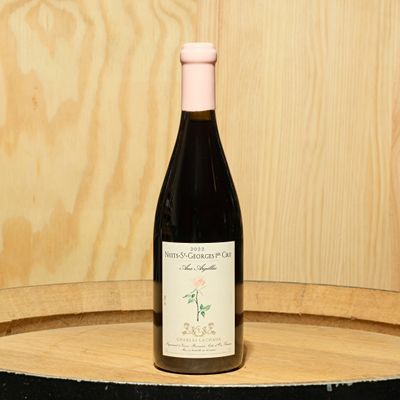a bottle of wine sitting on top of a barrel
