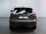 the back of a silver car in a room with a white wall