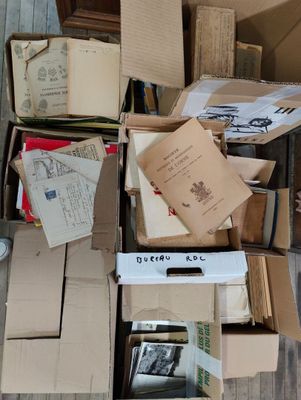 une boîte remplie de livres et de papiers posée par terre