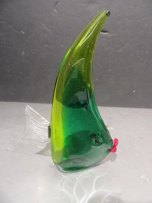 une figurine de poisson en verre posée sur une table