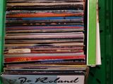 une boîte verte remplie d'une multitude de disques vinyles