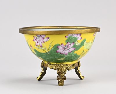 un bol jaune orné de fleurs violettes, posé sur un socle