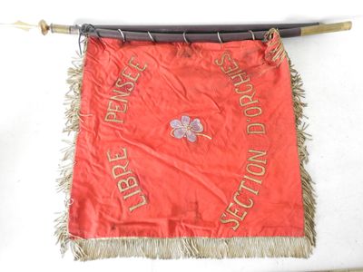 une banderole rouge accrochée à un mur à l'aide d'une perche en bois