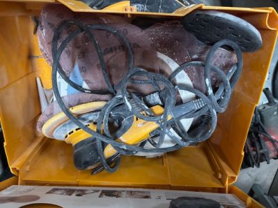 une boîte jaune posée par terre, contenant des outils