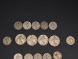 a group of silver coins on a black surface