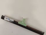un gros plan d'un stylo posé sur une surface blanche, avec un manche vert