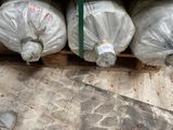 de nombreux rouleaux de plastique emballés dans des sacs en plastique, posés sur une palette