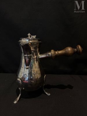 une cafetière ancienne en argent avec une poignée en bois, sur fond noir