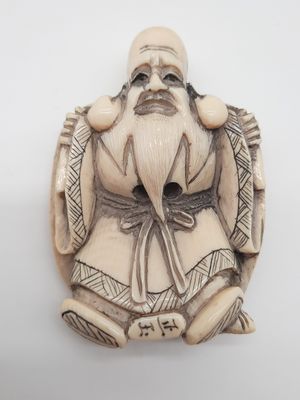 une vieille figurine sculptée représentant un homme barbu
