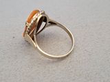 a ring with an orange stone in it on a table