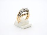 gros plan d'une bague en or et diamants sur une surface blanche