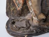 a statue of a man holding a fish on a rock