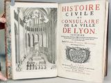 quelqu'un tient un livre dans lequel figure l'image d'un bâtiment