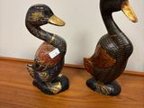 two ducks that are sitting on a wooden table
