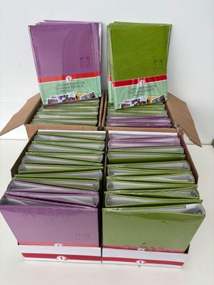 boxes of green and purple cards stacked on top of each other on a table