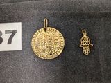 un gros plan sur une pièce d'or et un petit pendentif en or