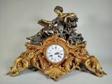 une horloge en or surmontée d'une statue