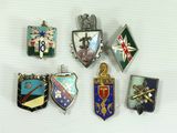 six different military badges are displayed on a white surface