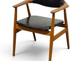 a wooden chair with black leather seat on a white background