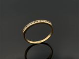 une bague en or avec des diamants sur une surface noire