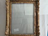 un vieux miroir à cadre doré accroché au mur, à côté d'un drapeau bleu et blanc