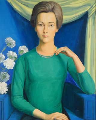 portrait of a woman in a green dress sitting in a blue chair