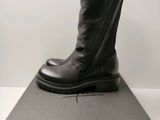 Les bottes noires sont posées sur la boîte, sur la table.