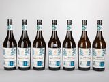 six bouteilles de vin sont alignées sur une table