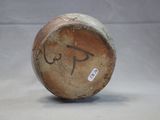 a close up of a brown vase with writing on it