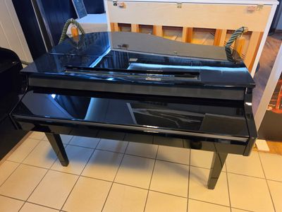 a black piano sitting on a tiled floor in a kitchen