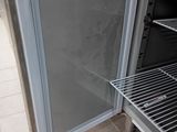 an open refrigerator that is sitting on a tiled floor