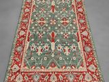 a green and red rug with a floral design